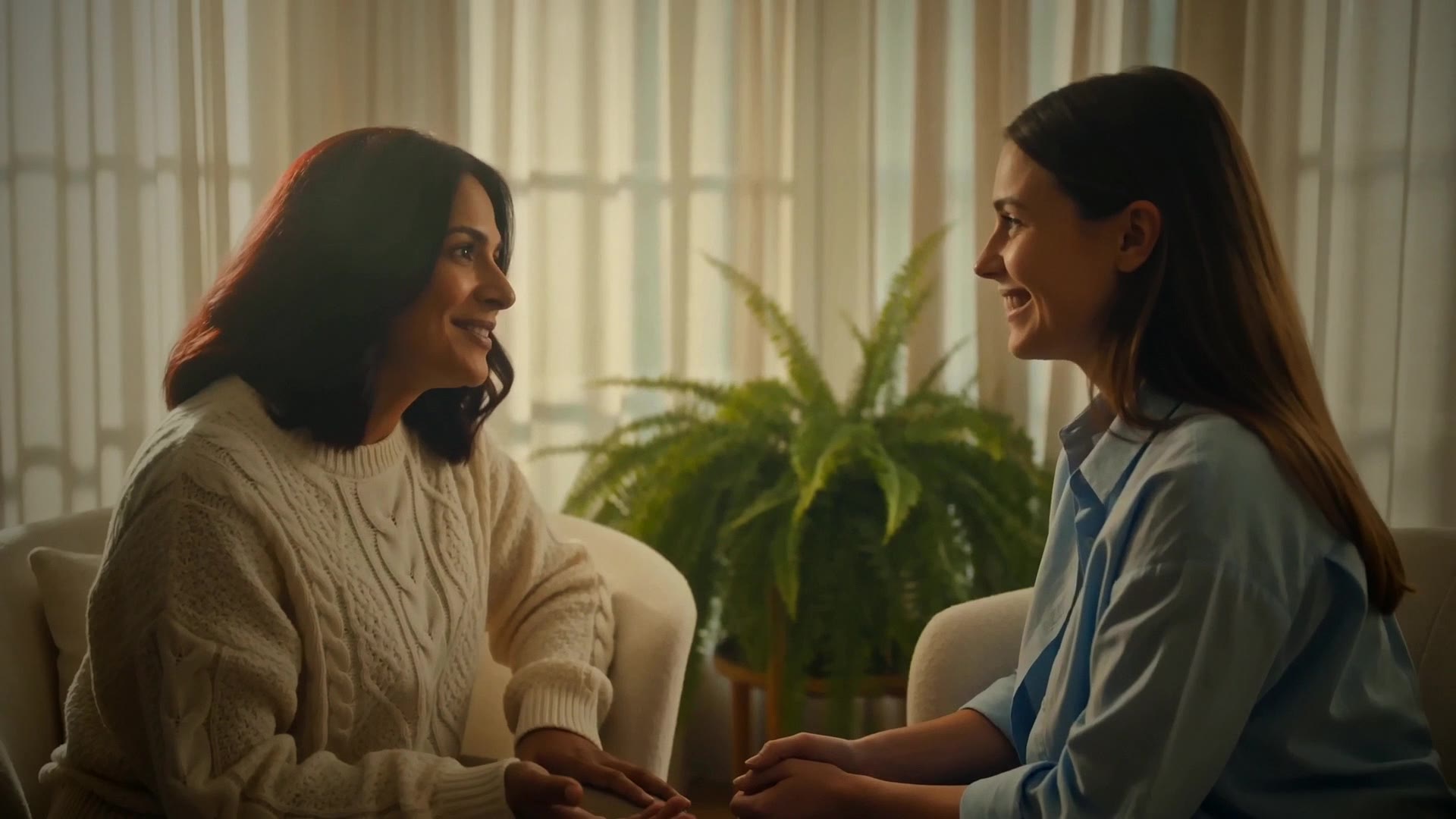 Two women laughing together in a sunlit coaching session